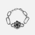 Silver-tone bracelet with paperclip chain links and a flower charm centered with a black stone