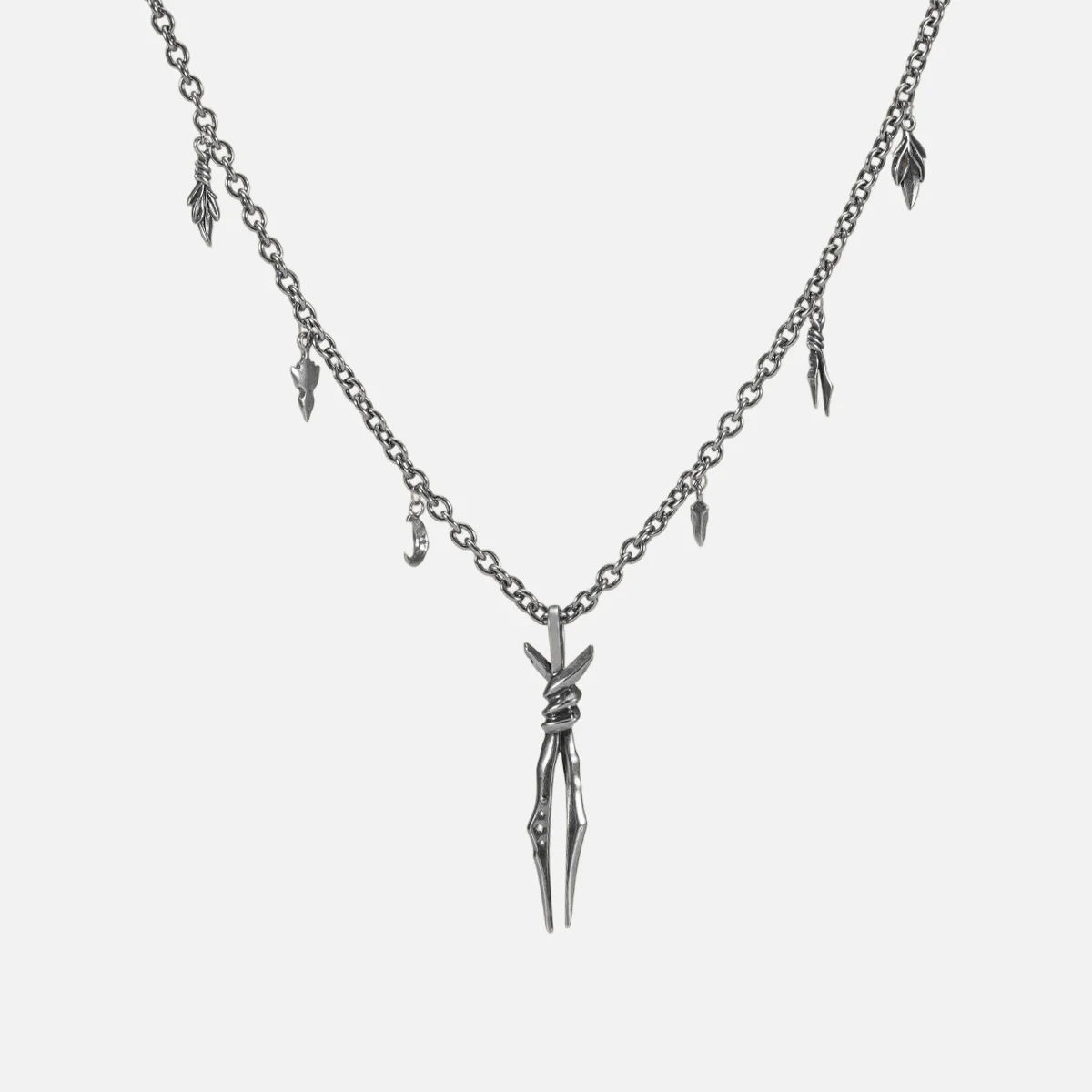 The silver-tone Bound Twin Necklace features a twin spike pendant, leaf charms, and an antiqued finish.