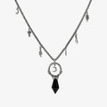 Silver Crescent Ward Necklace with black obsidian spike pendant, crescent moon charm, bone ring detail, and leaf-and-tooth chain accents on a clean background.