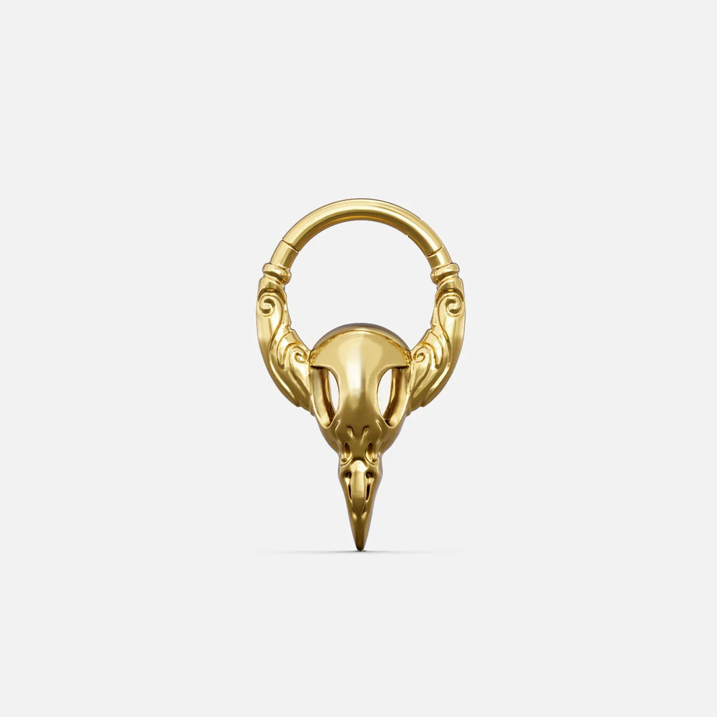 Gold-tone Gothic Raven Clicker with a sculpted raven skull, pointed beak, and decorative ring details.
