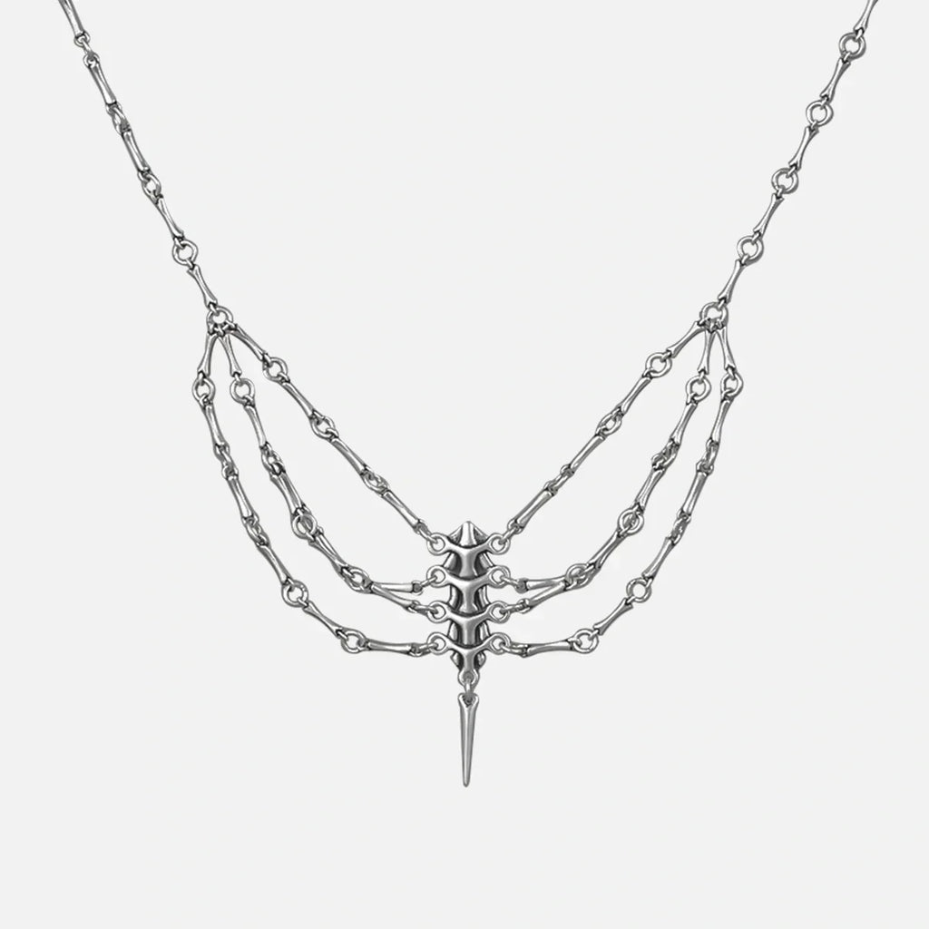 Silver-tone spine necklace with layered chains and a spike pendant, shown flat on a plain background