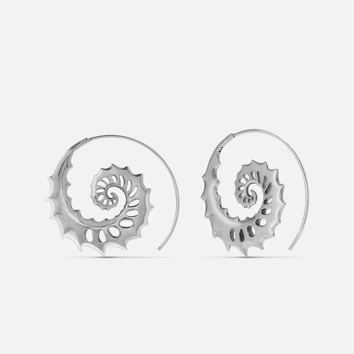 Silver Nautilus Omen Earrings with spiral shell shapes, cutout ridges, thorn-like edges, and hoop design on a clean background.