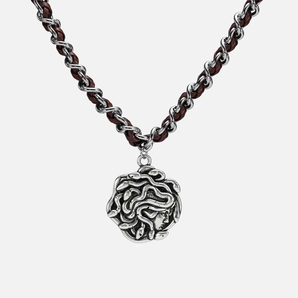 petrified power necklace in silver shown in a front close-up view, featuring a medusa-inspired pendant on a braided chain