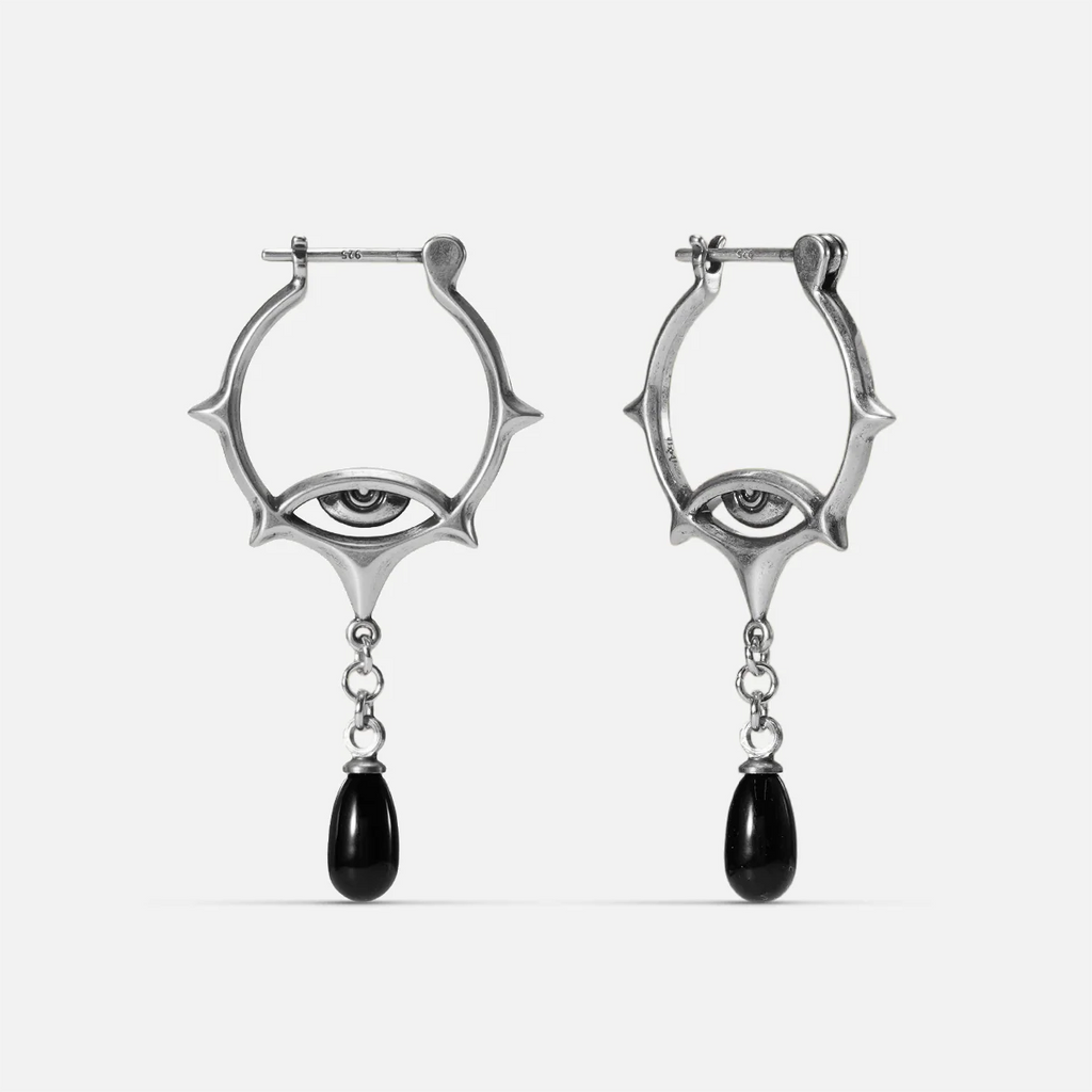 Antiqued silver-tone Thorned Gaze Hoop Earrings with open thorned frames, engraved eye motifs, and suspended black teardrop accents.