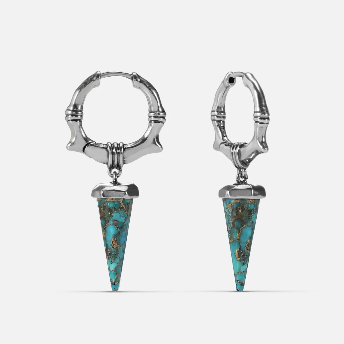 Silver-tone Unearthed Spike Earrings feature turquoise spike drops and bone-textured hoops.